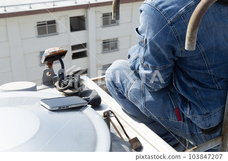 A worker inspecting an elevated water tank A worker inspecting an elevated water tank 103847207