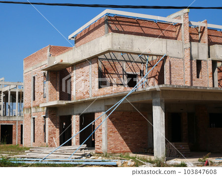 SEREMBAN, MALAYSIA -JUNE 17, 2021: New double-story terrace house under construction in Malaysia. Designed by an architect with a modern and contemporary style. Almost completed. SEREMBAN, MALAYSIA -JUNE 17, 2021: New double-story terrace house under construction in Malaysia. Designed by an architect with a modern and contemporary style. Almost completed. 103847608