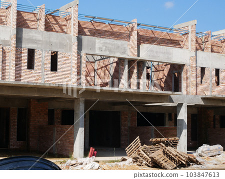 SEREMBAN, MALAYSIA -JUNE 17, 2021: New double-story terrace house under construction in Malaysia. Designed by an architect with a modern and contemporary style. Almost completed. SEREMBAN, MALAYSIA -JUNE 17, 2021: New double-story terrace house under construction in Malaysia. Designed by an architect with a modern and contemporary style. Almost completed. 103847613