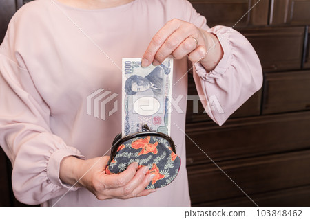 [A housewife takes out a 1000 yen bill from her clasp] 103848462