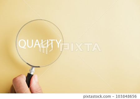 Magnifying glass against enhances the word Quality emphasizing the concept of control and compliance. It represents the rules, policies, and regulations that ensure the company's Terms and Conditions. 103848656