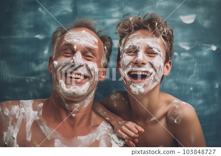 Dad and son with shaving foam on their faces have fun spending time together. Ai 103848727
