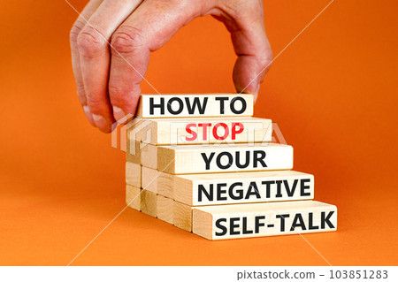 Stop negative self-talk symbol. Concept words How to stop your negative self-talk on wooden block. Psychologist hand. Beautiful orange background. Psychological negative self-talk concept. Copy space 103851283