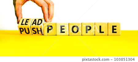 Lead or push people symbol. Concept word Lead people and Push people on wooden cubes. Beautiful yellow table white background. Businessman hand. Business Energy or hunger crisis concept. Copy space. 103851304