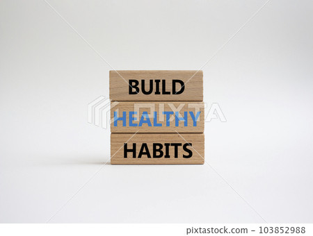 Healthy habits symbol. Concept word Build Healthy habits on wooden blocks. Beautiful white background. Healthy lifestyle and Healthy habits concept. Copy space 103852988