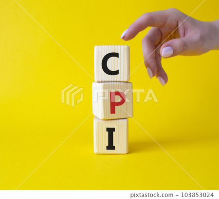 CPI - Consumer Price Index symbol. Concept word CPI on wooden cubes. Businessman hand. Beautiful yellow background. Business and CPI concept. Copy space. CPI - Consumer Price Index symbol. Concept word CPI on wooden cubes. Businessman hand. Beautiful yellow background. Business and CPI concept. Copy space. 103853024
