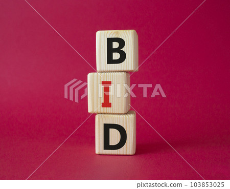 BID symbol. Concept word BID on wooden blocks. Beautiful red background. Business and BID concept. Copy space 103853025