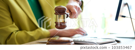 Woman hand striking with judge gavel in court room 103853467