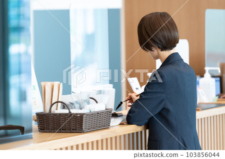 商人在酒店前台辦手續（出差/預訂） 103856044