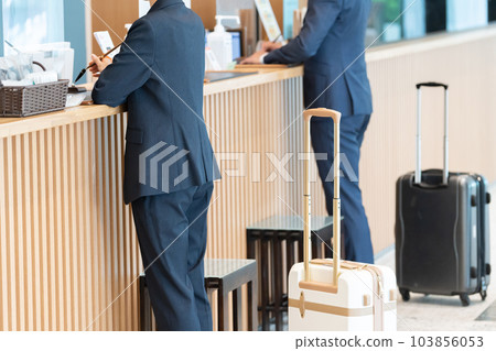 商人在酒店前台辦手續（出差/預訂） 103856053