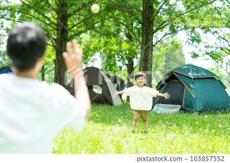 Parents and children playing ball at the campsite 103857552