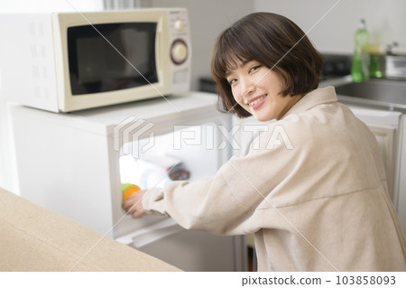 從冰箱裡拿出飲料的年輕女人 103858093