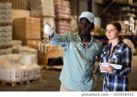 Man and woman working in warehouse, talking about job 103858432
