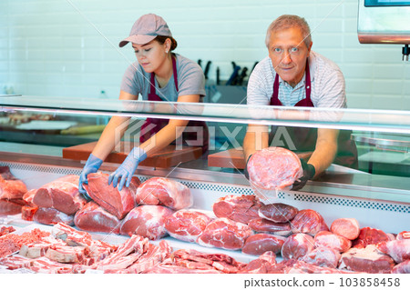 Male farmer of meat products in butcher shop offers to buy fresh beef tenderloin. Male farmer of meat products in butcher shop offers to buy fresh beef tenderloin. 103858458