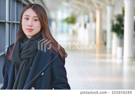 young woman wearing a blue coat 103859289