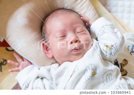 Baby sleeping in a cot 103860941