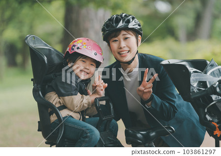 Wearing a bicycle helmet for both mother and child 103861297