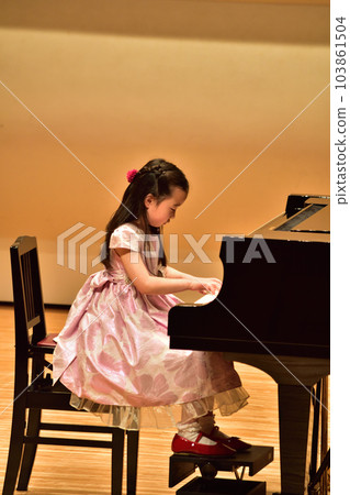 Girl playing the piano at the 2023 recital (3rd grade) Girl playing the piano at the 2023 recital (3rd grade) 103861504
