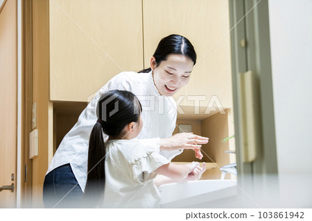 Parent and child washing hands in the washroom 103861942