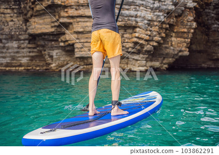 Young men Having Fun Stand Up Paddling in blue water seaamong the rocks in Montenegro. SUP 103862291