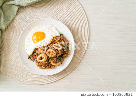 fried rice with squid and basil topped fried egg in Thai style fried rice with squid and basil topped fried egg in Thai style 103863921