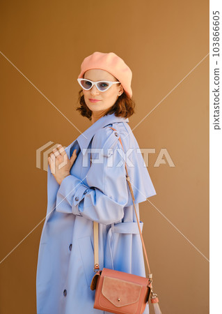 Pretty woman in coat, hat and sunglasses turned back 103866605