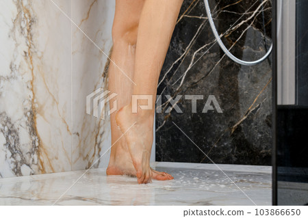 Wet female feet in shower cabin 103866650