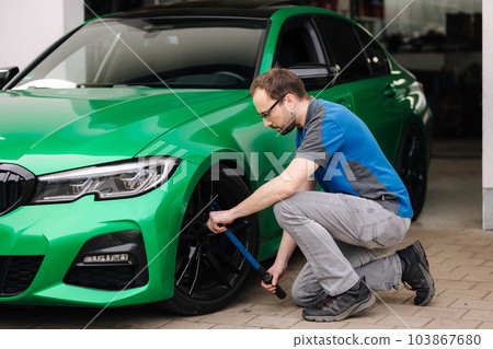 Mechanic checking tire service via insurance system at garage. Safety vehicle. Wheel check 103867680
