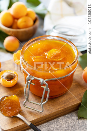 Homemade preservation. Delicious apricots jam or jelly on a stone table. Homemade preservation. Delicious apricots jam or jelly on a stone table. 103868018