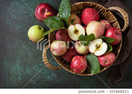 Fruit background, organic fruits. Still life food. Basket of ripe apples on a stone table. View from above. Copy space. Fruit background, organic fruits. Still life food. Basket of ripe apples on a stone table. View from above. Copy space. 103868021
