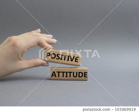 Positive attitude symbol. Concept words Positive attitude on wooden blocks. Beautiful grey background. Businessman hand. Business and Positive attitude concept. Copy space. 103869919