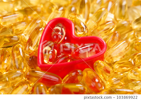 Yellow capsule medicine close up. Heart health concept 103869922