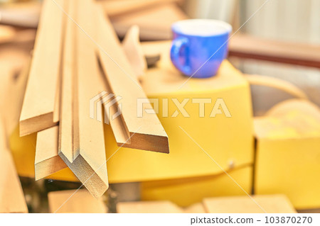 Planks, boards in a carpentry workshop and a blue cup Planks, boards in a carpentry workshop and a blue cup 103870270