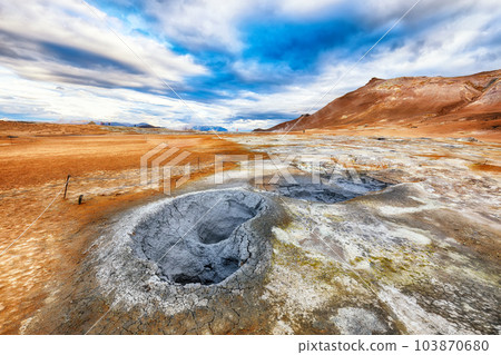 Breathtaking boiling mudpots in geothermal area Hverir and cracked ground around. Breathtaking boiling mudpots in geothermal area Hverir and cracked ground around. 103870680
