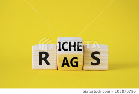 Rags vs Riches symbol. Wooden cubes with words Rags and Riches. Beautiful yellow background. Rags vs Riches and business concept. Copy space 103870786