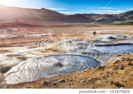 Breathtaking boiling mudpots in geothermal area Hverir and cracked ground around. Breathtaking boiling mudpots in geothermal area Hverir and cracked ground around. 103870808