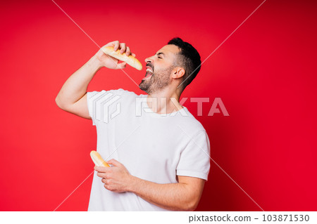 Man with freshly baked bread in the hands isolated on red background studio Man with freshly baked bread in the hands isolated on red background studio 103871530