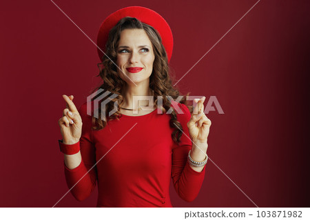 excited elegant woman on background with crossed fingers 103871982