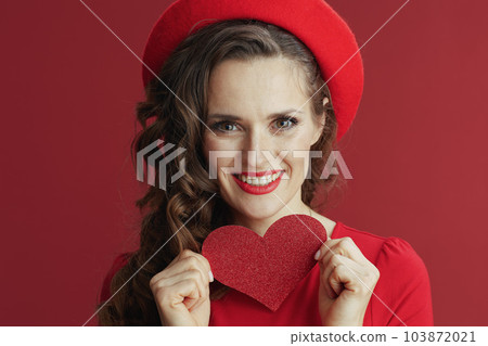 happy stylish woman in red dress and beret on red background 103872021