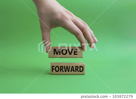 Move forward symbol. Wooden blocks with words Move forward. Beautiful green background. Businessman hand. Business and Move forward concept. Copy space. Move forward symbol. Wooden blocks with words Move forward. Beautiful green background. Businessman hand. Business and Move forward concept. Copy space. 103872279
