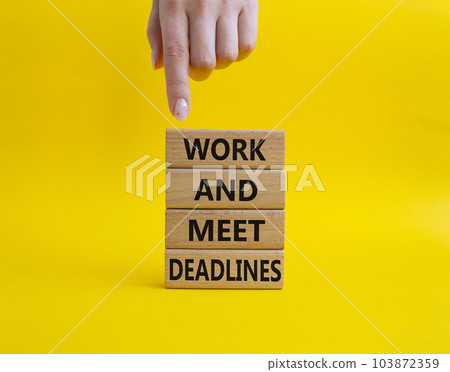 Work and deadline symbol. Concept words Work and meet deadlines on wooden blocks. Beautiful yellow background. Businessman hand. Business and Work and meet deadlines concept. Copy space. 103872359