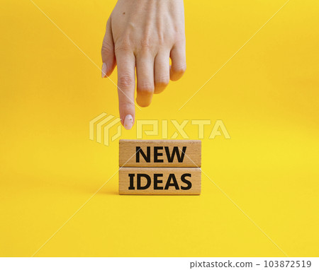 New ideas symbol. Concept word New ideas on wooden blocks. Beautiful yellow background. Businessman hand. Business and New ideas concept. Copy space New ideas symbol. Concept word New ideas on wooden blocks. Beautiful yellow background. Businessman hand. Business and New ideas concept. Copy space 103872519