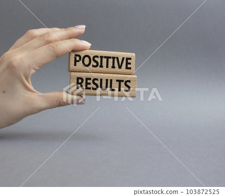Positive results symbol. Concept words Positive results on wooden blocks. Beautiful grey background. Businessman hand. Business and Positive results concept. Copy space. 103872525