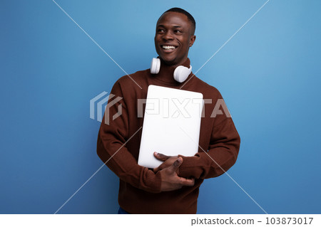 young american student studying offline with laptop and headphones on background with copy space young american student studying offline with laptop and headphones on background with copy space 103873017