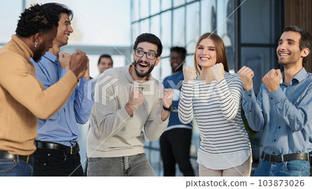 Business people celebrates and clench their fists in the air as a winning team 103873026