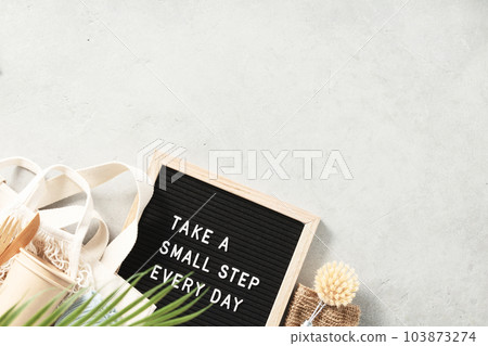 Take a small step every day letter board and zero waste no plastic accessories on grey stone background 103873274