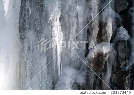 frozen icicles and icing on a stone wall in winter frozen icicles and icing on a stone wall in winter 103873449