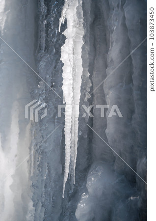 frozen icicles and icing on a stone wall in winter frozen icicles and icing on a stone wall in winter 103873450