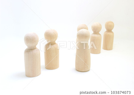 the Wooden figures of people stand in a row. 103874073