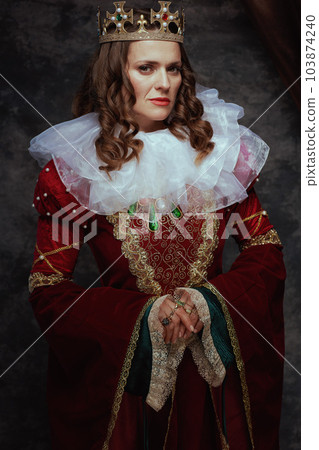 medieval queen in red dress with white collar and crown 103874240